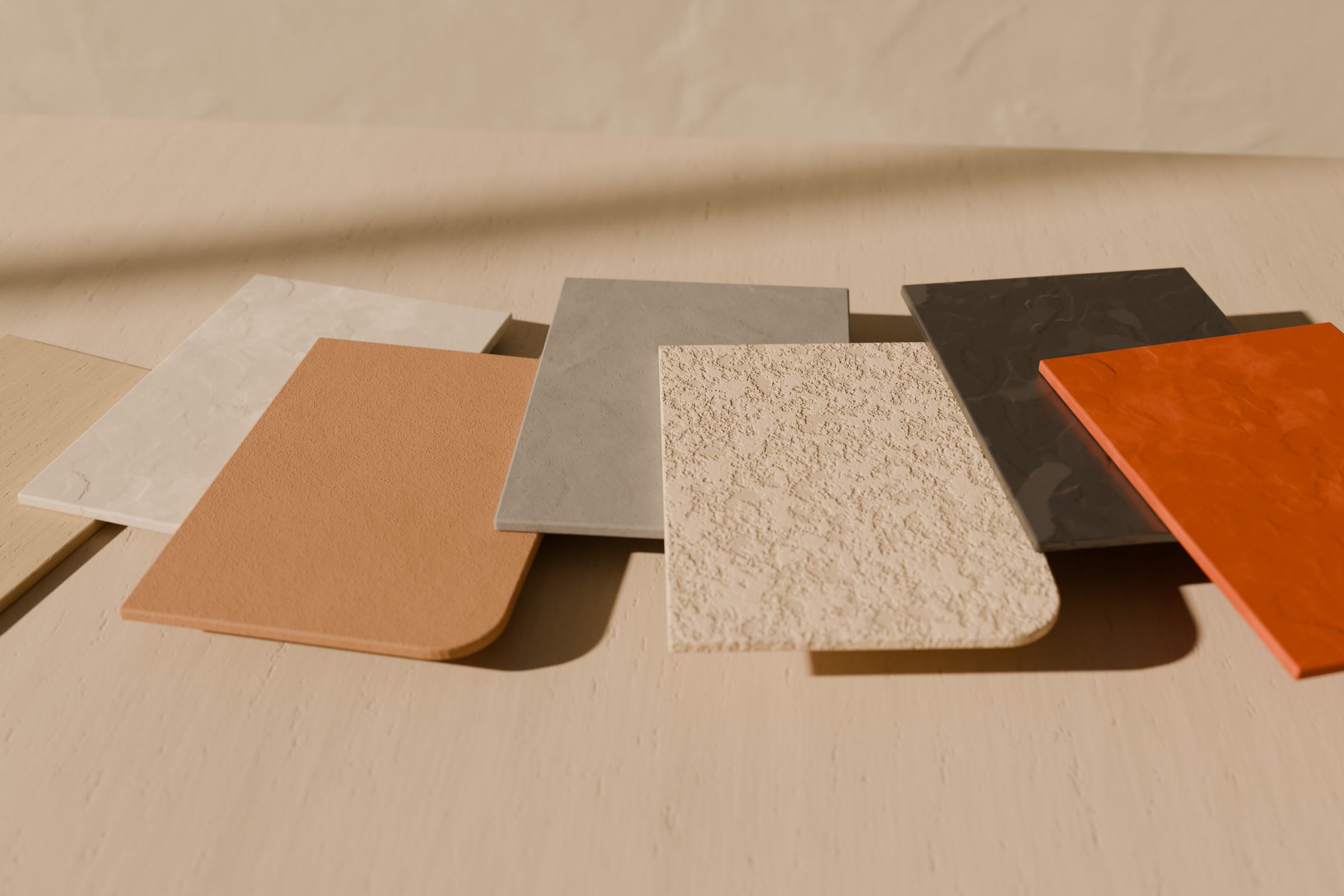 Concept render of DragMort-style sample boards in several finishes and colours fanned out on a stone table in window light.